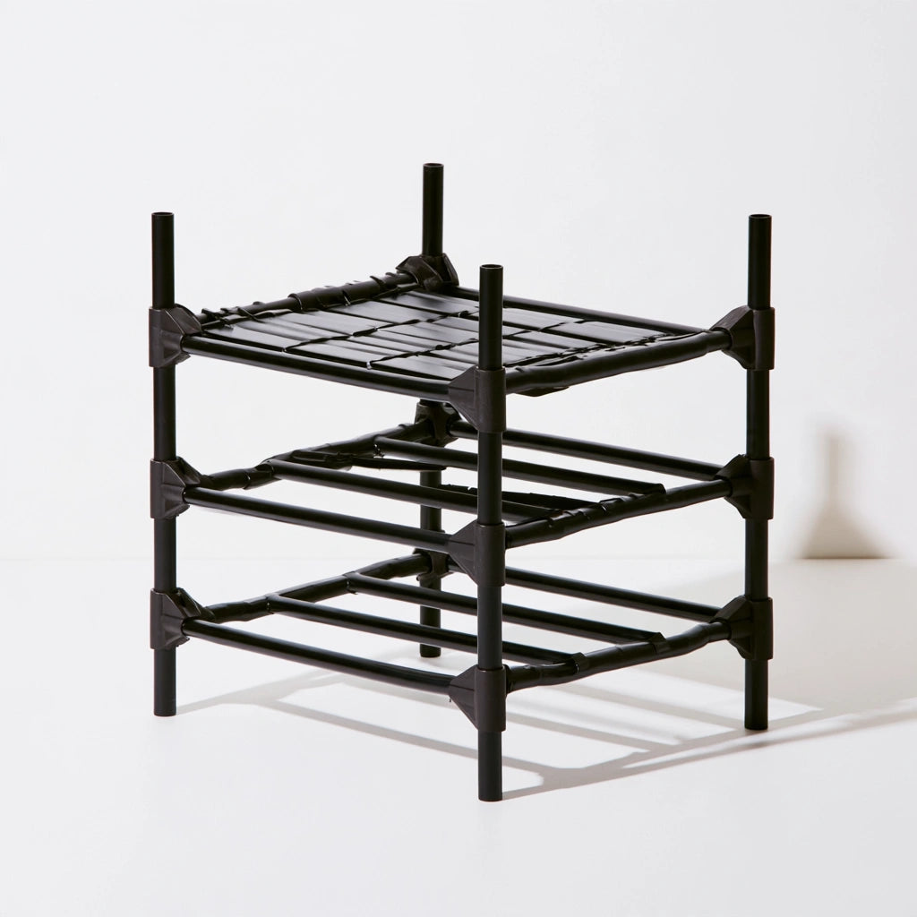 Black metal shoe rack from ledgeandlilac, three-quarter view showing multiple horizontal bars for organizing shoes.
