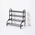 Black metal shoe rack by LedgeandLilac, three-quarter view showing multiple tiers for organizing shoes.