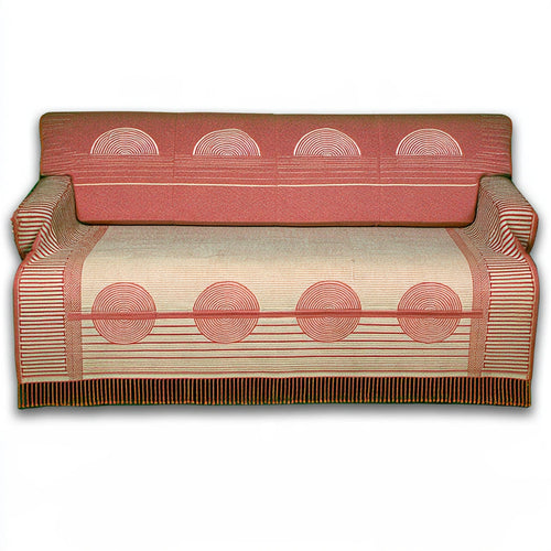 Gray upholstered three-seater sofa from LedgeandLilac draped with a woven jacquard throw blanket.